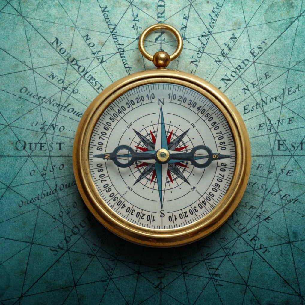 Magnetic old compass on world map. Travel, geography, history, navigation, tourism and exploration concept background. Retro compass on geography map.
